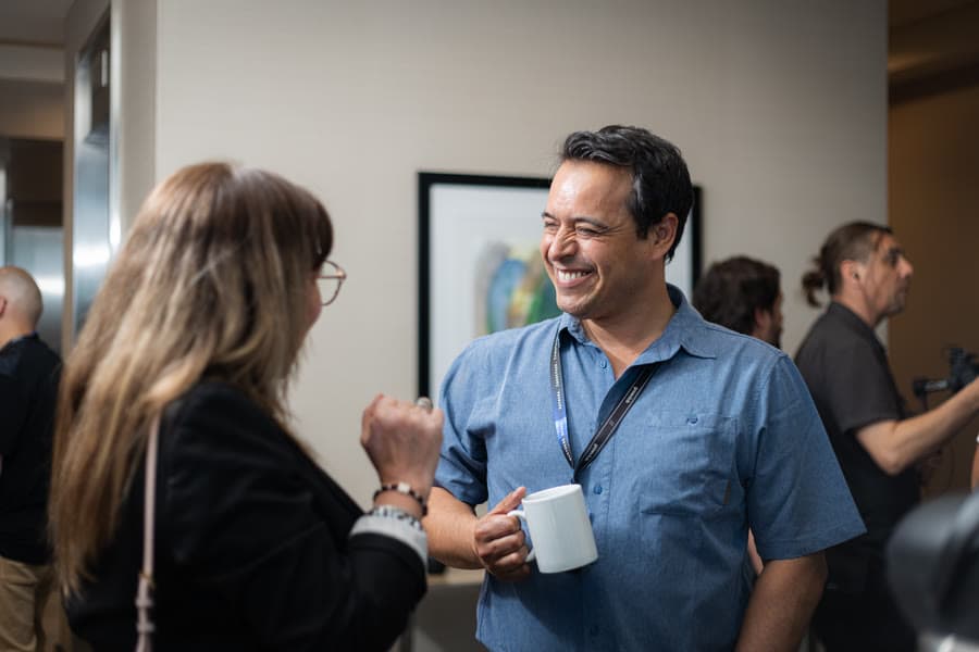 Dos participantes conversando con café en el receso