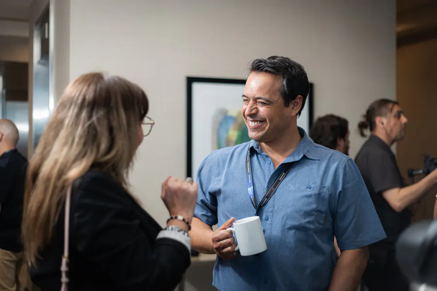 Dos participantes conversando con café en el receso
