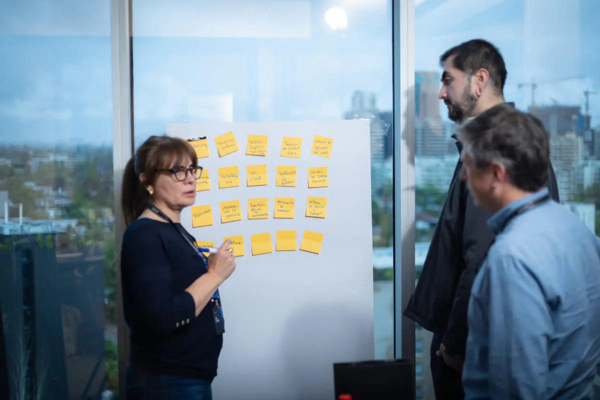 Equipo trabajando frente a un muro de post-its