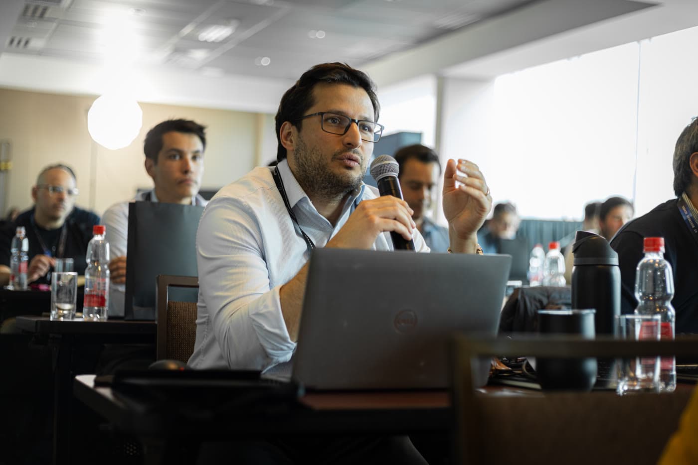 Participante con su laptop abierto explica al grupo lo que construyó