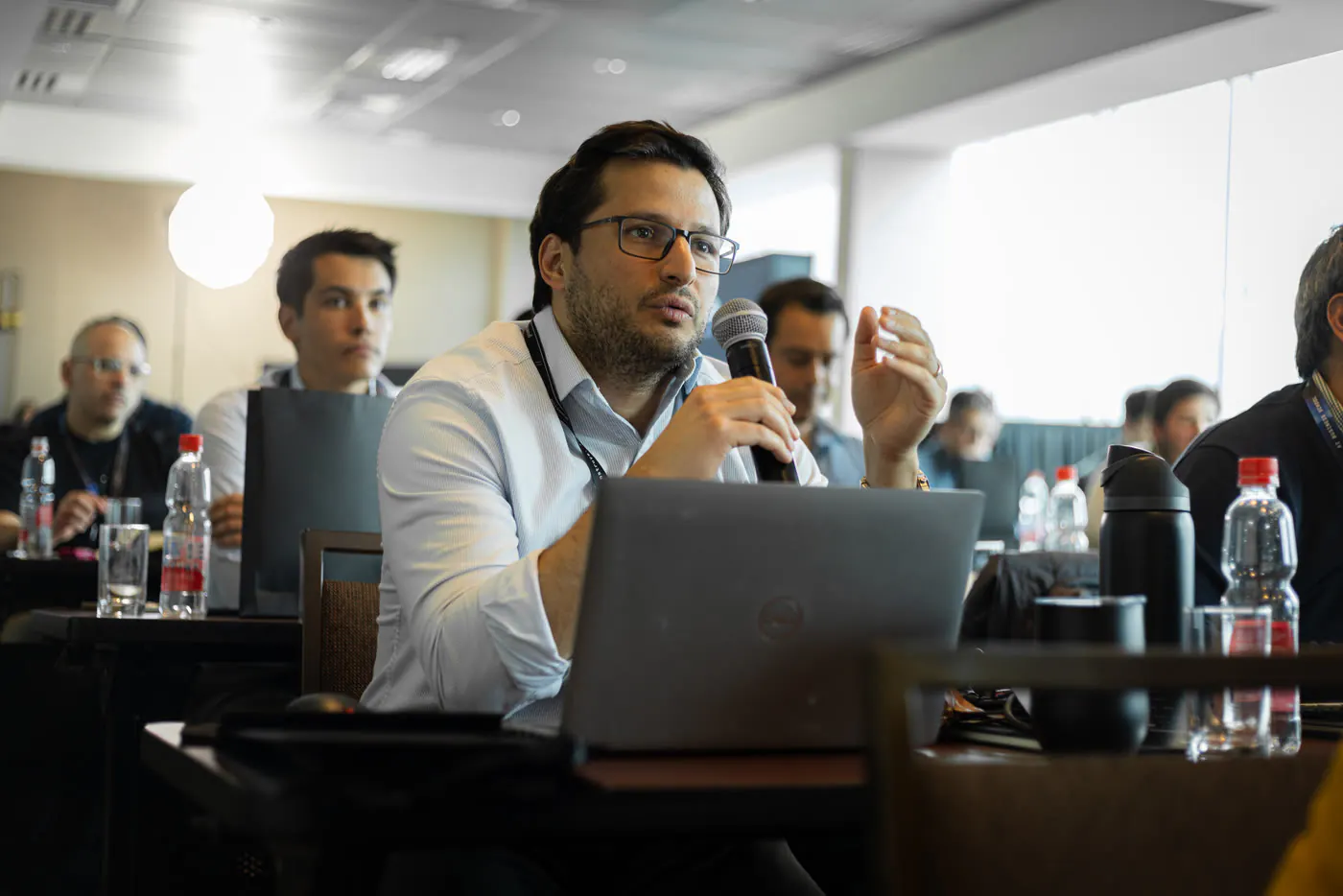 Participante con su laptop abierto explica al grupo lo que construyó